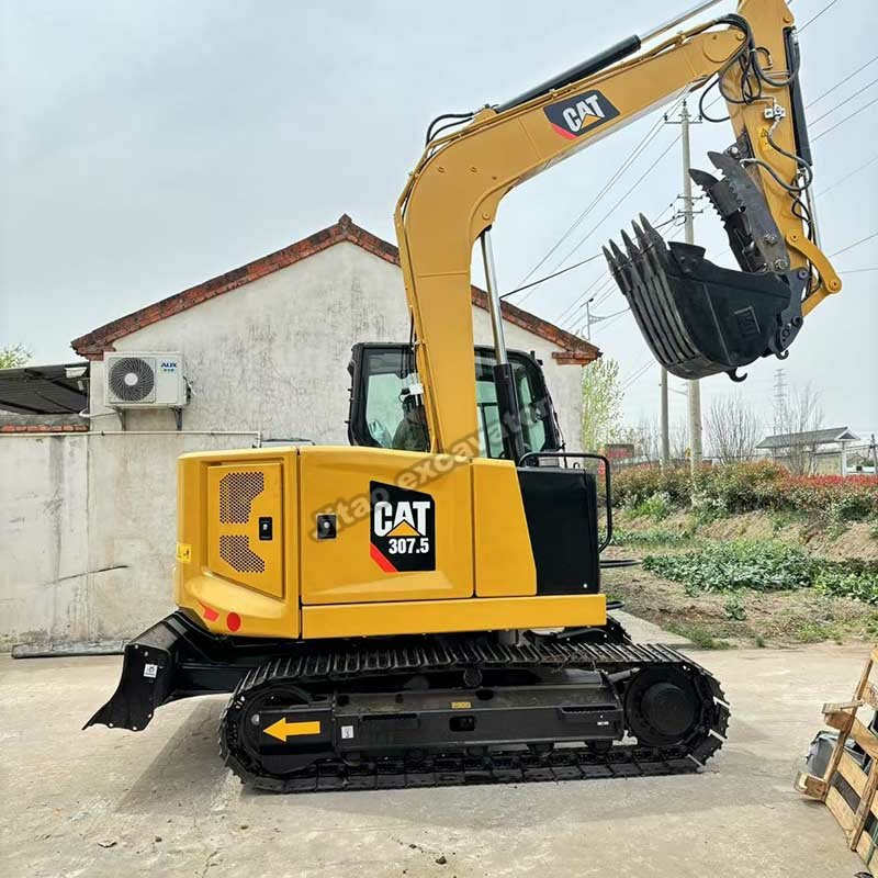 Side view showing the bucket and arm of a CAT 307.5 mini excavator.