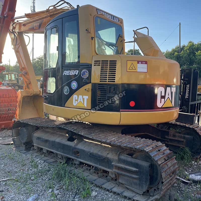 Side view of a yellow Cat 313C, a versatile base for a used post hole digger setup.