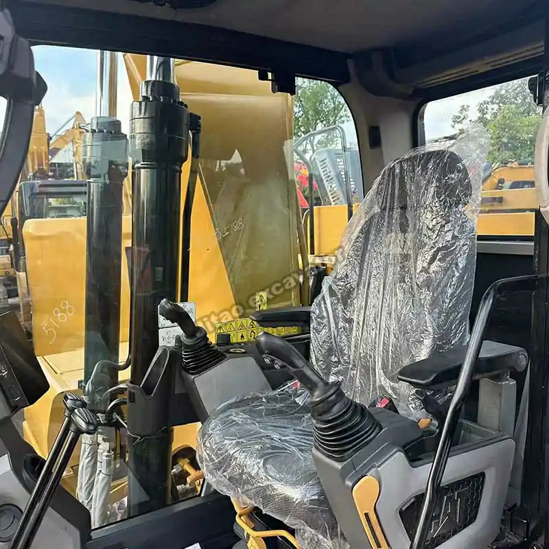 Interior view of the Cat 323 cabin showing the seat and joysticks.