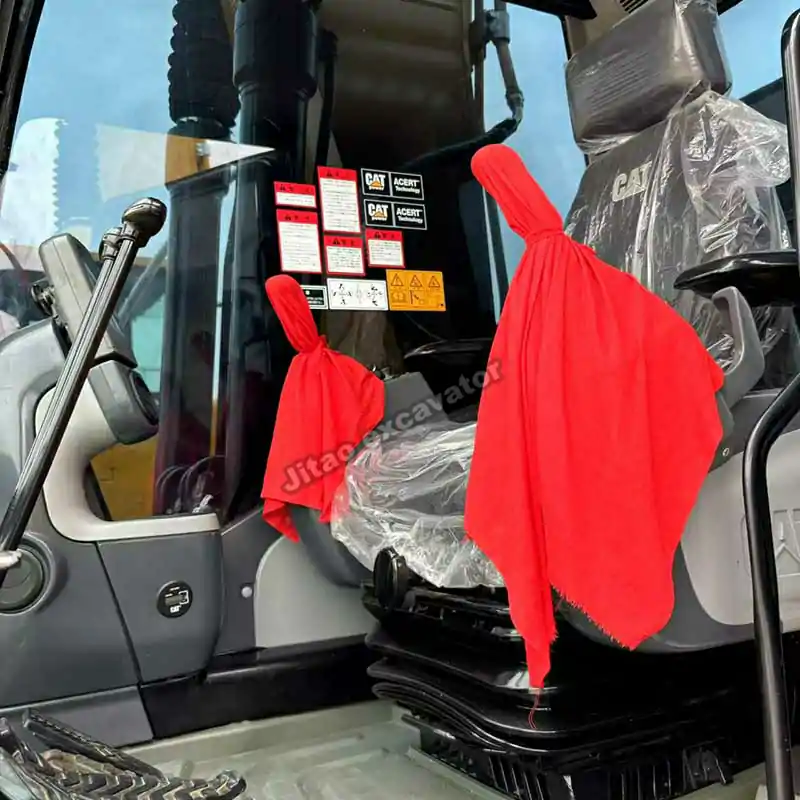 Interior of the Cat 323D2L cabin showing the joystick and seat covers.