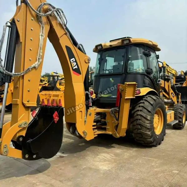 Rear digging arm and stabilizers of a Caterpillar backhoe loader.