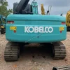 Rear view of the Kobelco SK140 demonstrating safety rails and engine cover.