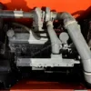 Close-up view of the Doosan DX225 engine and hydraulic pump compartment.