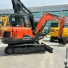 Side angle of the Doosan DX60 mini excavator showing its compact design.