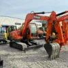 Full side profile of the Doosan DX75 showcasing its robust boom and chassis.