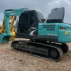 Side view of the Kobelco SK140 showcasing its reinforced boom and clean body.