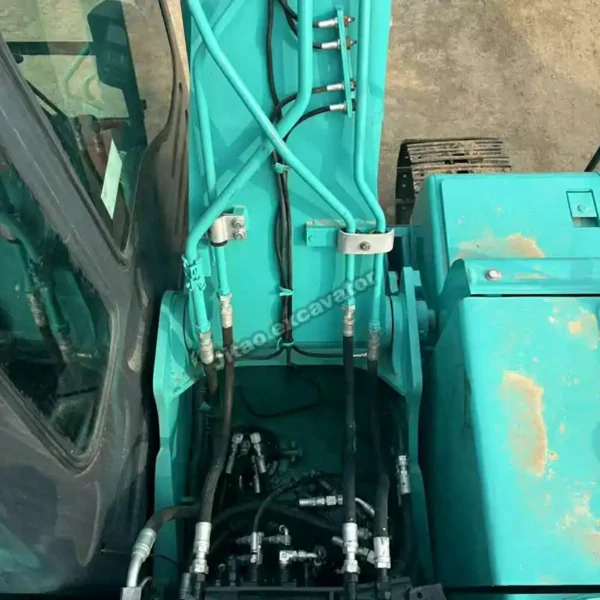 Certified Mechanical Health Top view of the Kobelco SK130 engine and hydraulic pump compartment.