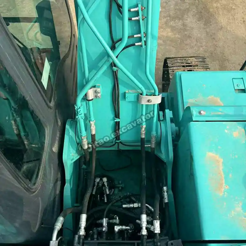 Top view of the Kobelco SK130 engine and hydraulic pump compartment.