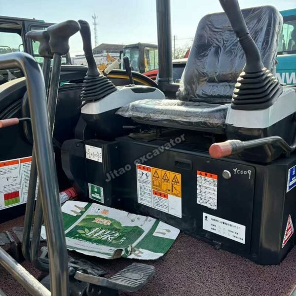 View of the operator station and control levers of a Komatsu PC30MR machine.