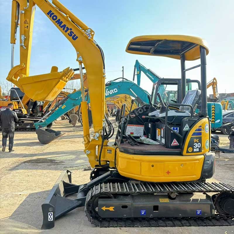 Side view of a yellow Komatsu PC30MR, a top-tier used small excavator for sale at Jitao yard.