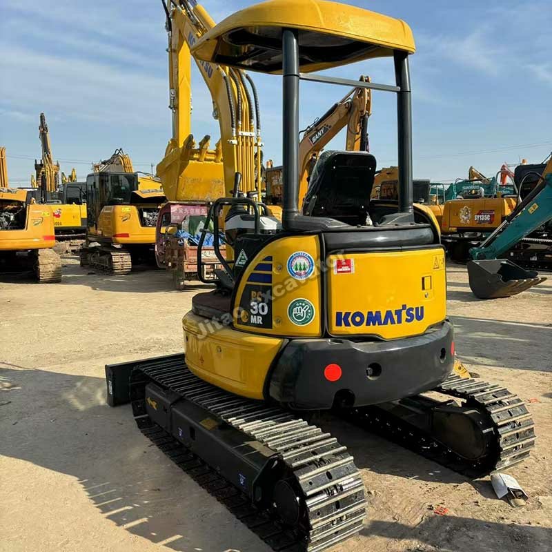 Side profile of a Komatsu PC30 showing the undercarriage and rubber tracks in good condition.