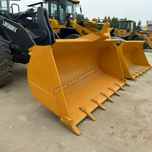 Close-up of the reinforced bucket on a used loader backhoe for sale.