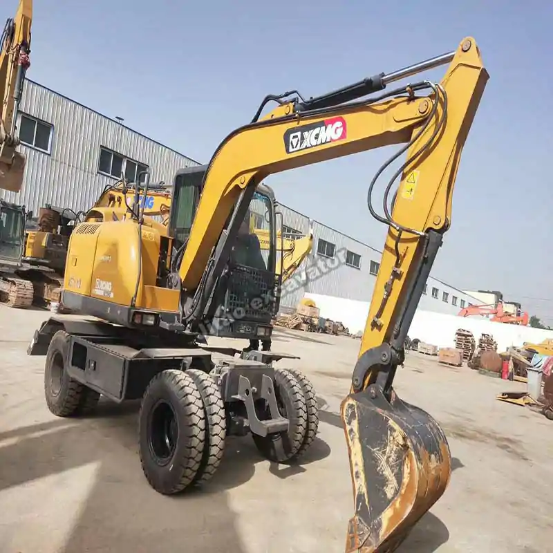 Closer side view showing the boom and wheels of a wheeled mini excavator.
